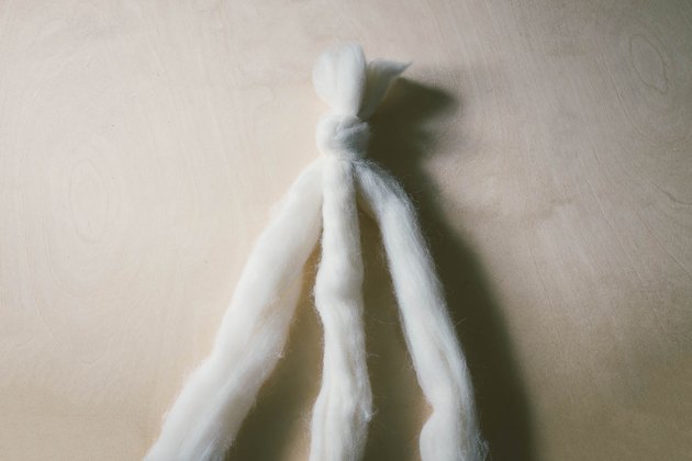 Three strands of ivory wool roving knotted together