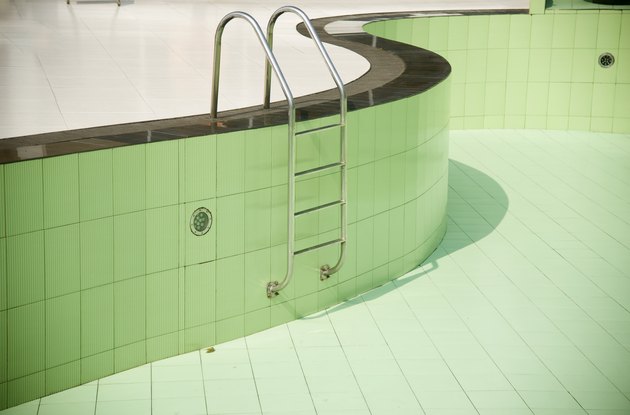 An empty swimming pool with metallic stairs