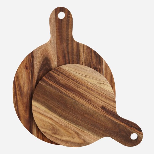 Two round paddle-style cutting boards made of acacia wood.
