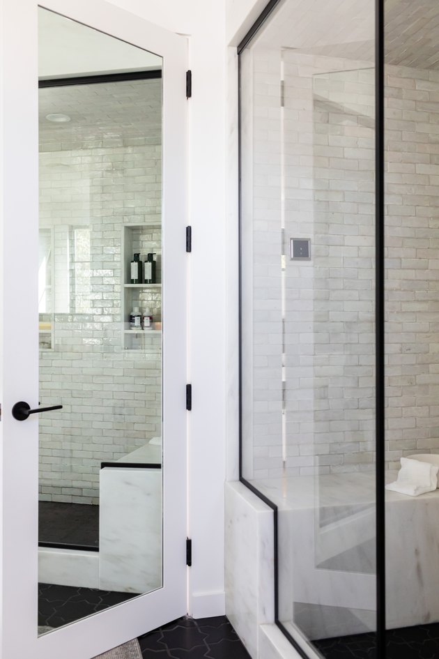 Bathroom door with a full-length mirror and a glass door shower