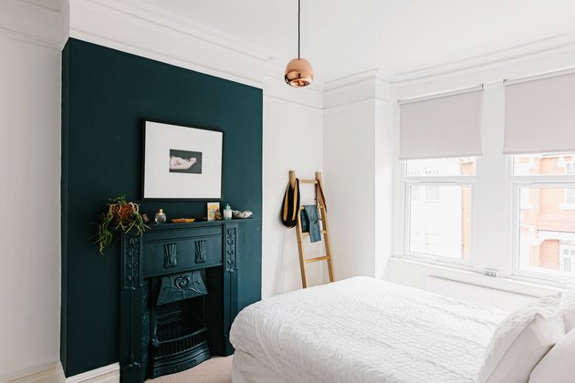 Dark turquoise color idea for mantle against white wall in small bedroom with windows and ladder propped against wall