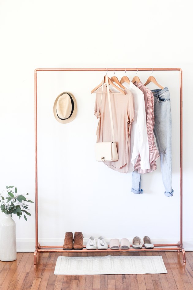 a clothing rack with a shoe rack attached made from copper pipe