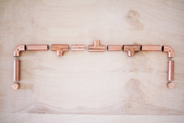 several short pieces of pipe, including t-joints and elbow fittings, laid out for a dry fitting