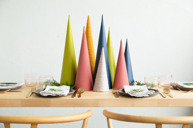 Christmas decor idea with a diy holiday centerpiece made of colorful cardboard cones, sprigs of greenery, and faux snow