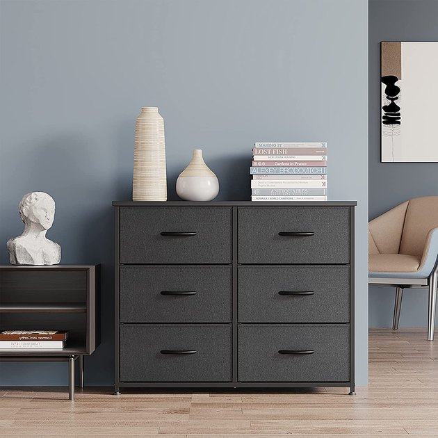 This dresser features fabric drawers protected by a durable steel frame and a wood top perfect for showcasing your favorite pieces of decor.