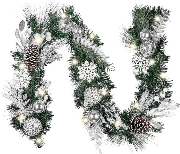 This stunning, six-foot garland features all the beauty of a white Christmas without the freezing temperatures. With faux frosted pine cones and pine needles, silver ornaments, and battery-powered LED lights with eight light effects, Valery Madelyn Pre-Lit Frozen Winter Christmas Garland is sure to help bring on the holiday cheer.