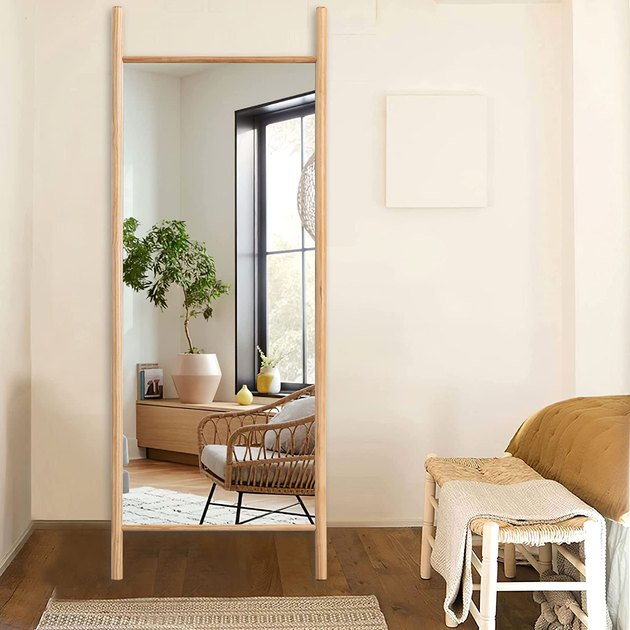 Instead of a standard rectangle mirror, opt for a ladder design instead. This pick has a blonde wood frame that’s equally neutral and stylish.