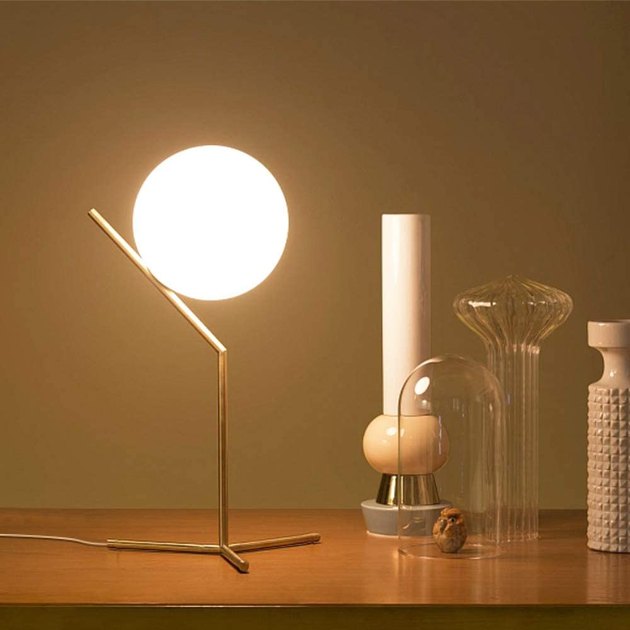 It doesn't get any sleeker than this midcentury modern table lamp. Featuring a gold metal base and frosted glass shade, this accent piece is the perfect addition to your nightstand, side table, or home office. 
