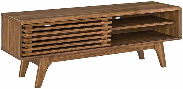 You won’t compromise storage for style with this TV stand. This low-profile design gives off a major vintage vibe with a sliding slatted door, open shelving, and a walnut grain finish.