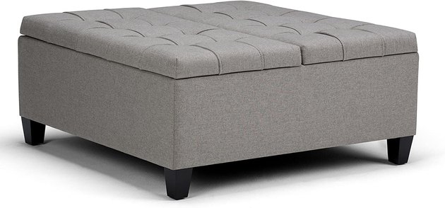 This ottoman conveniently has a pull out top on one side that acts as a coffee table and a hinged lid storage space on the other side.

