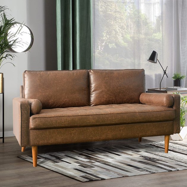 This loveseat is perfect for two — and anyone looking to achieve a midcentury modern aesthetic at home. It features a tufted cushion, tapered wood legs, and faux leather upholstery.