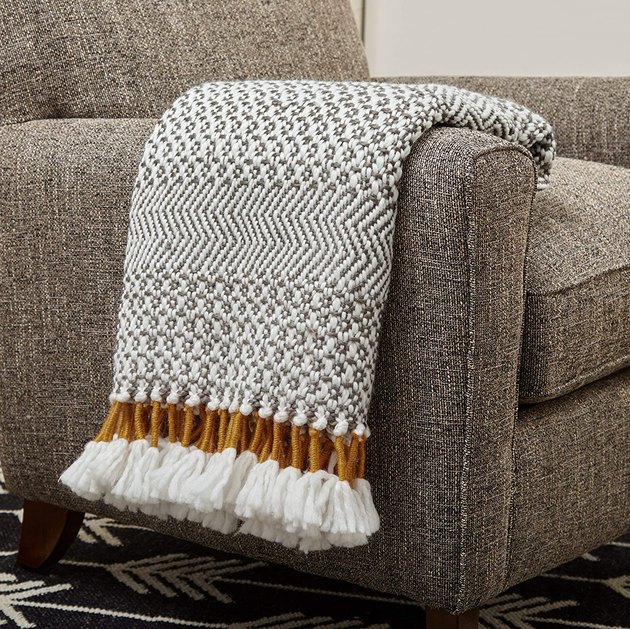 With its textural tassels and diamond and herringbone pattern, this timeless blanket can seamlessly transition from the living room to the bedroom. 
