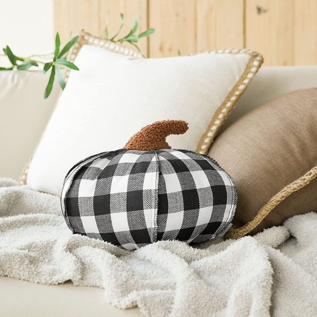 This pumpkin-shaped pillow proves seasonal decor can indeed be chic. Select from a black and white, green and white, or red and black plaid design. Plus, the plush stem on top may just be the cutest thing ever.