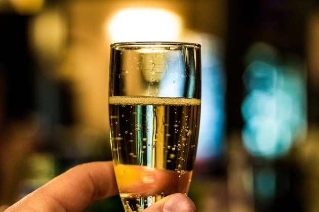 Glass of Sparkling Wine (Champagne-type wine) Raised to Make a Toast
