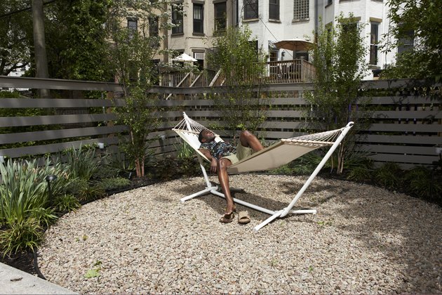 Man relaxing in urban backyard hammock