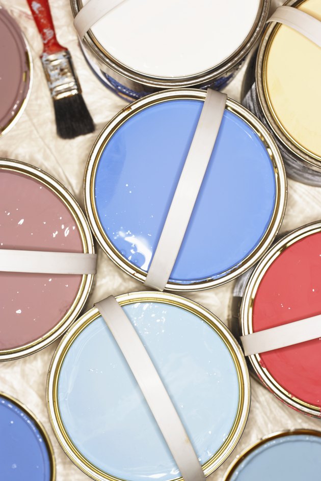 Open tins of paint on plastic covered floor, overhead view