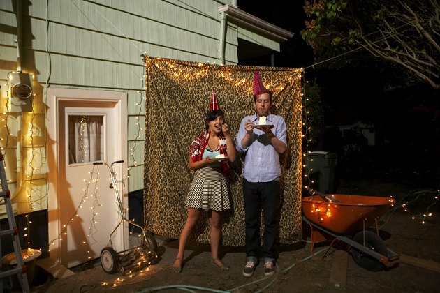 Young couple standing by leopard curtain at party