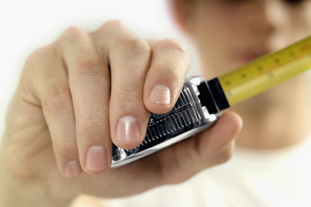 Man holding measuring tape, close-up, selective focus