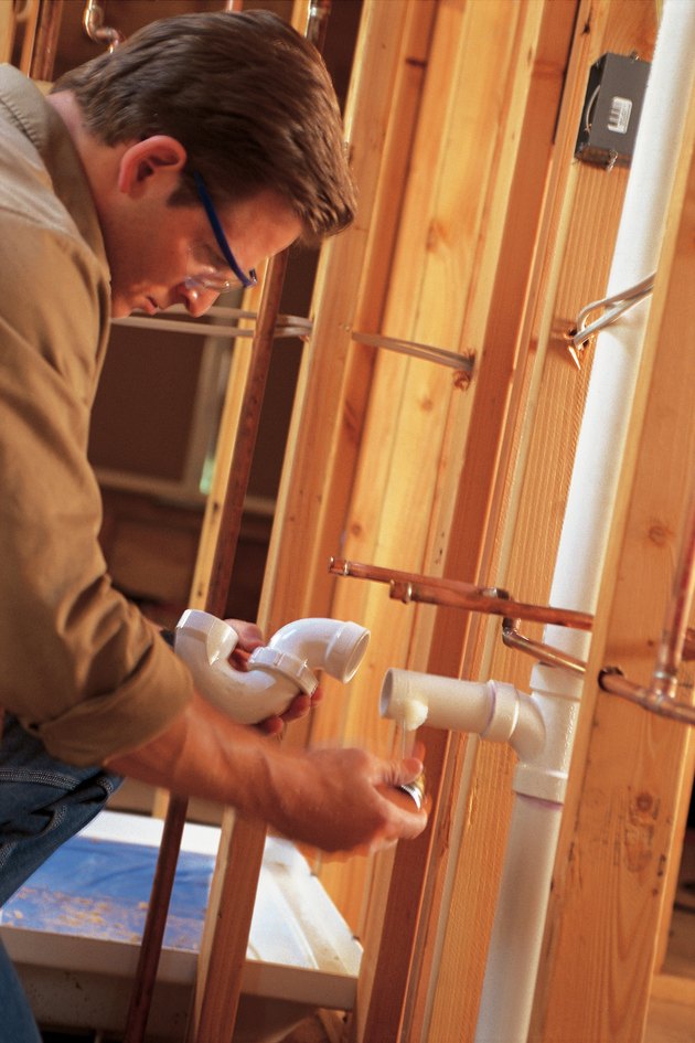 Plumber installing pipes