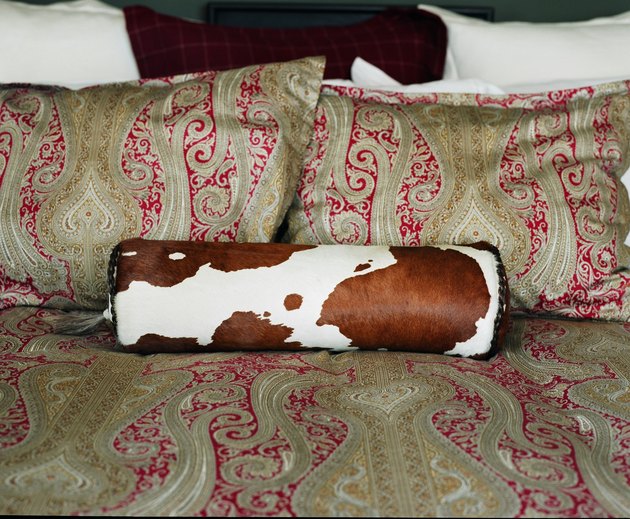 Paisley pattern of bed and pillows with roll cushion in cowhide