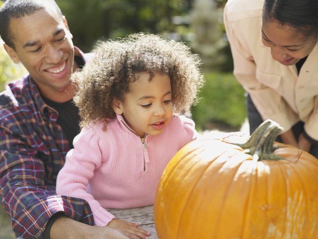 African family looking at pumpkin