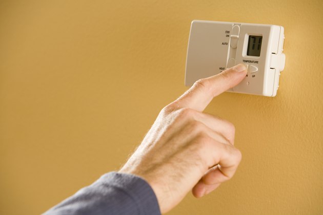 Person adjusting thermostat