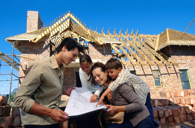 Family with blueprints at construction site