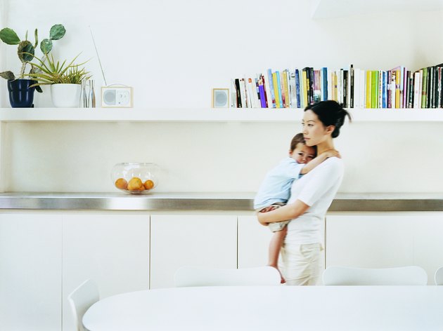 Mother Carrying Her Young Son Through Her Dining Room