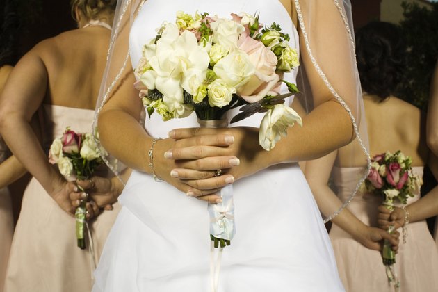 Close up of Hispanic bride holding bouquet