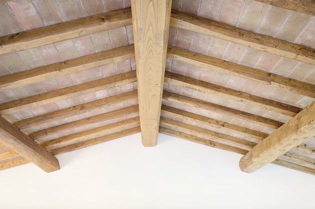 Tuscan traditional wood beam ceiling, red bricks, wall. Italy