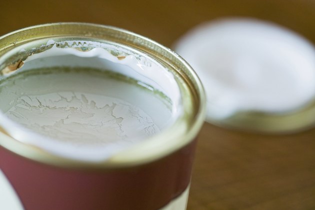 Pot of green paint, open, lid near by, close up