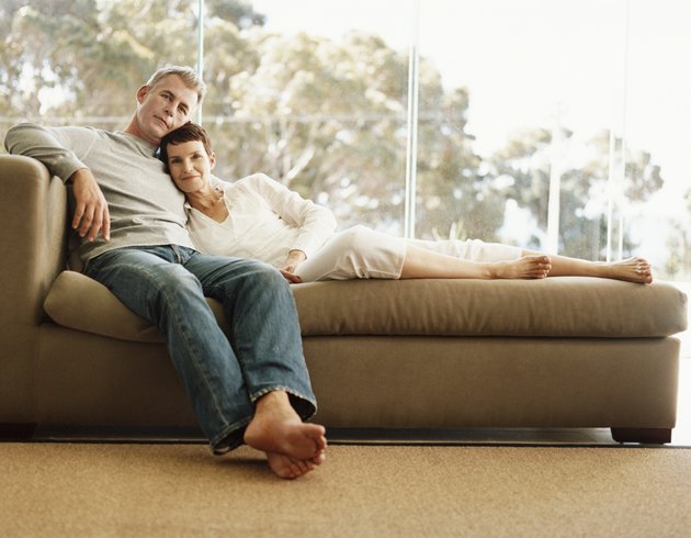 Mature Couple on a Chaise-Lounge in Front of a Window With a View of Trees