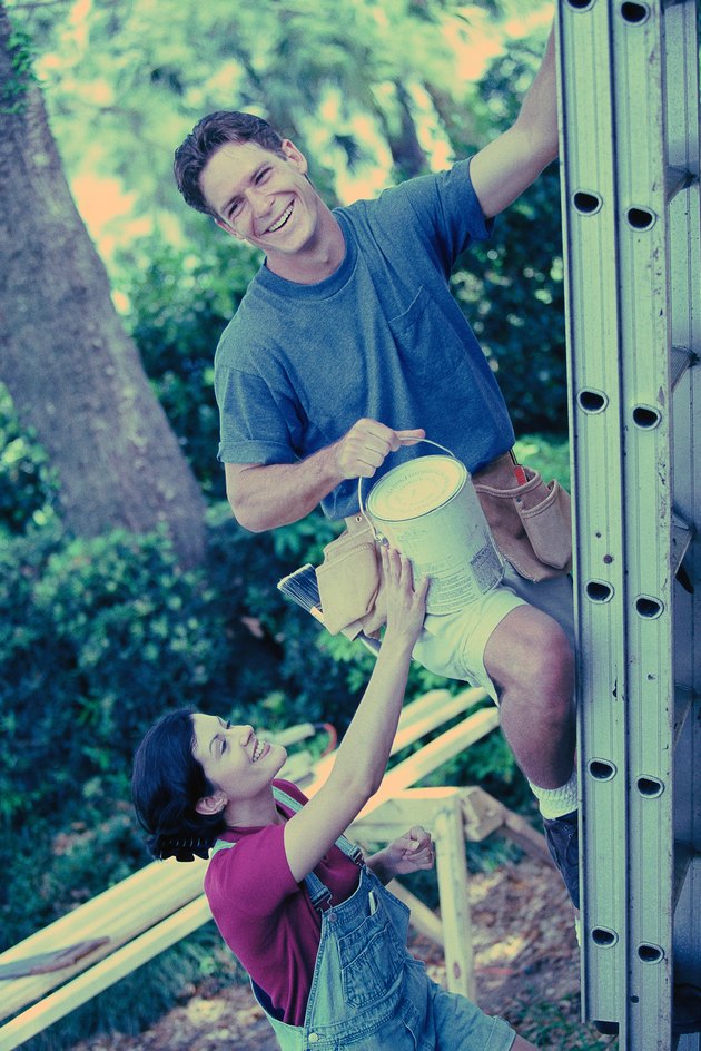 Man and woman painting house
