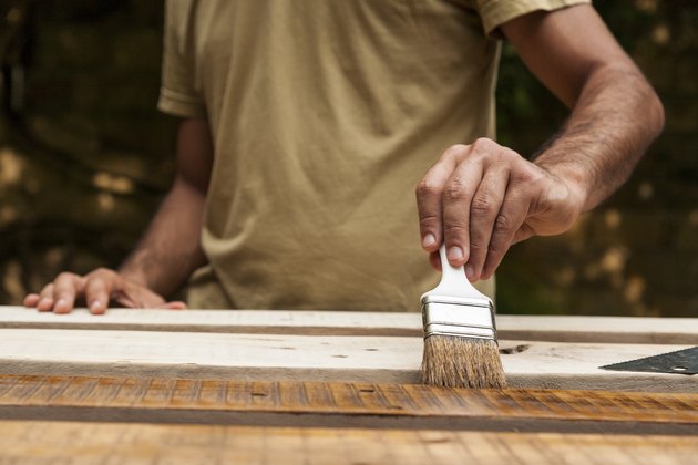 Close up of man painting a fence