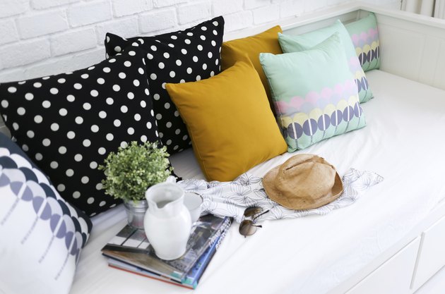 Colorful pillows on a sofa with white brick wall background