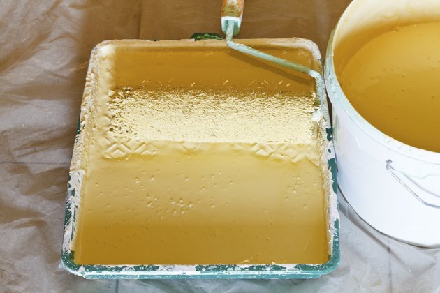 roller brush and bucket with yellow paint
