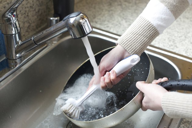 Close up of woman scrubbing pan