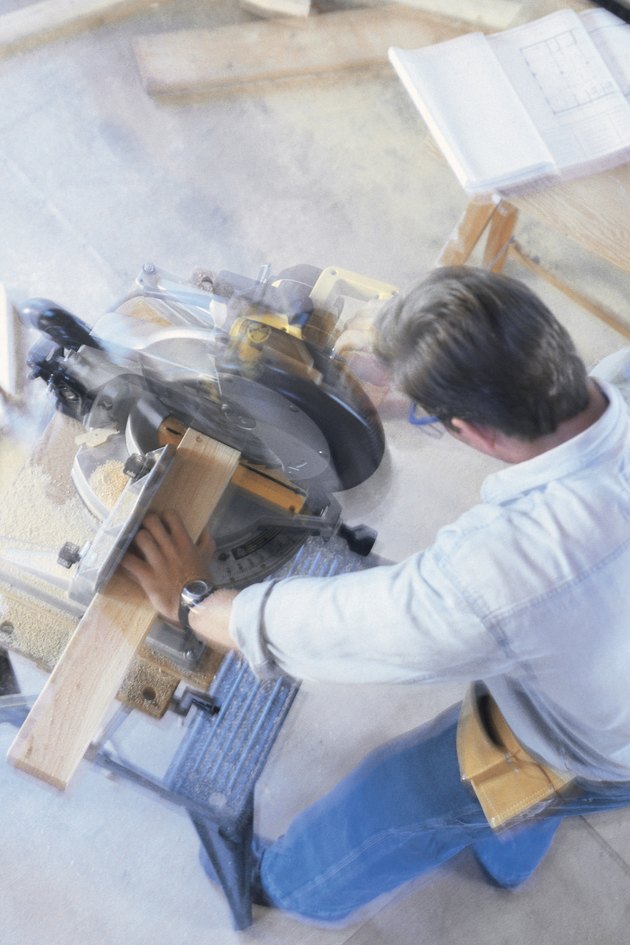 Construction worker using a miter saw