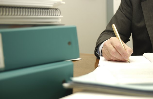 Busy businessman writing paperwork
