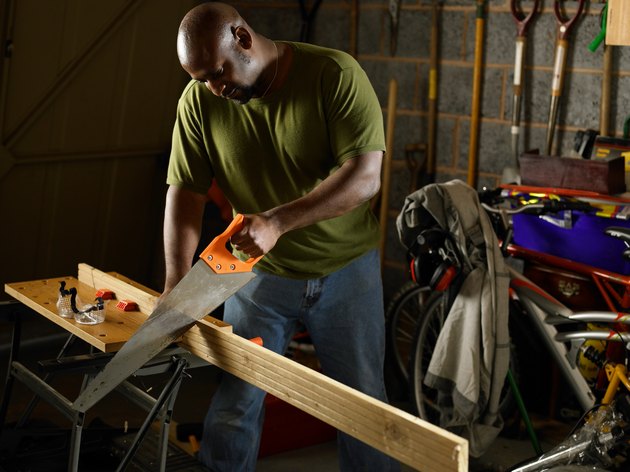 Man sawing wood in garage