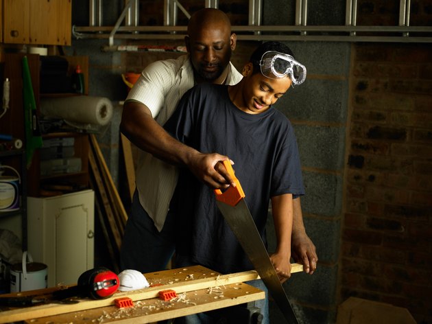 Father helping teenage Son with woodwork