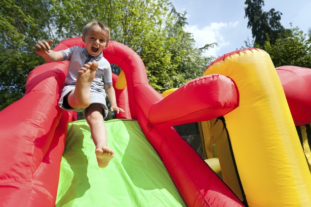 Child on inflatable bouncy castle slide