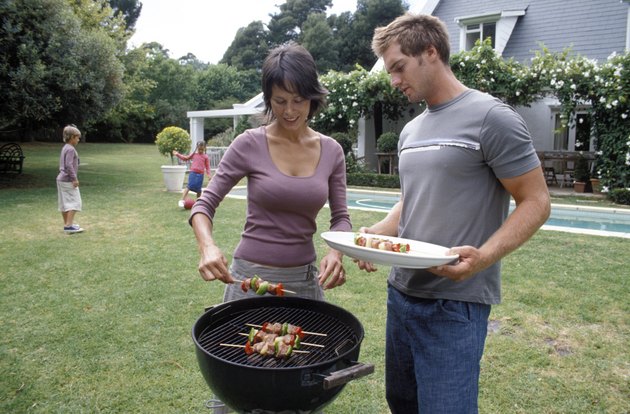 Parents at grill while are playing