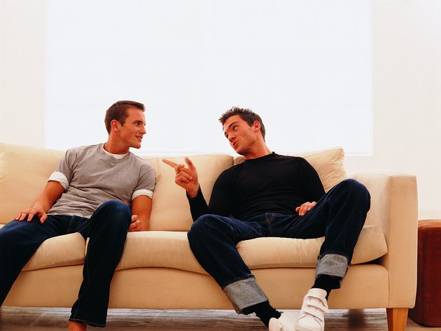 Two guys sitting together, one telling a story