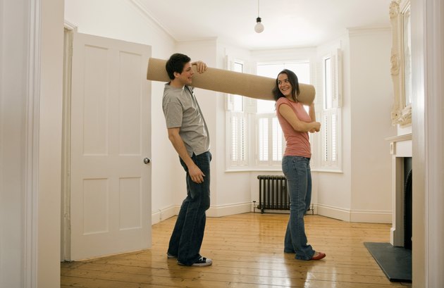 Couple carrying carpet roll