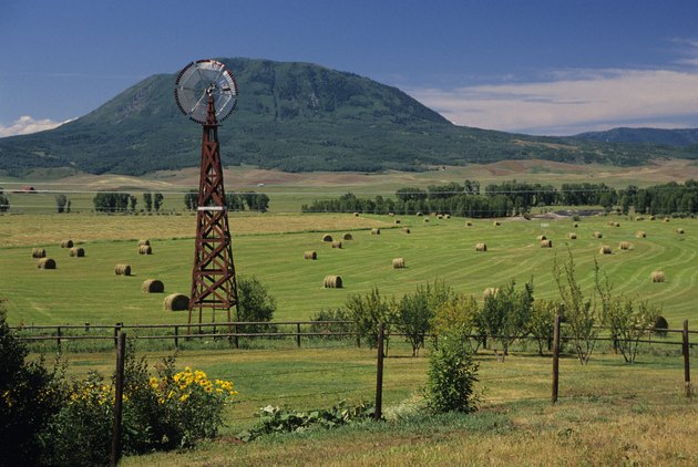 Windmill and haystacks on farm, Steamboat Springs, Colorado, USA