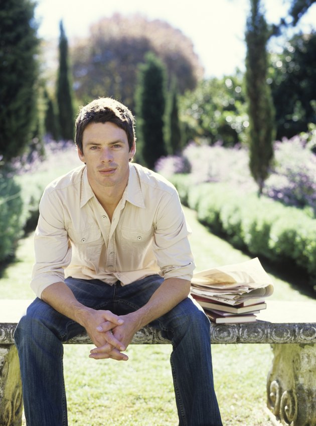 Man sitting on bench in garden, portrait