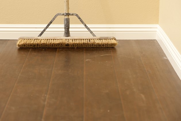 Push Broom on Newly Installed Dusty Laminate Floor and Baseboard