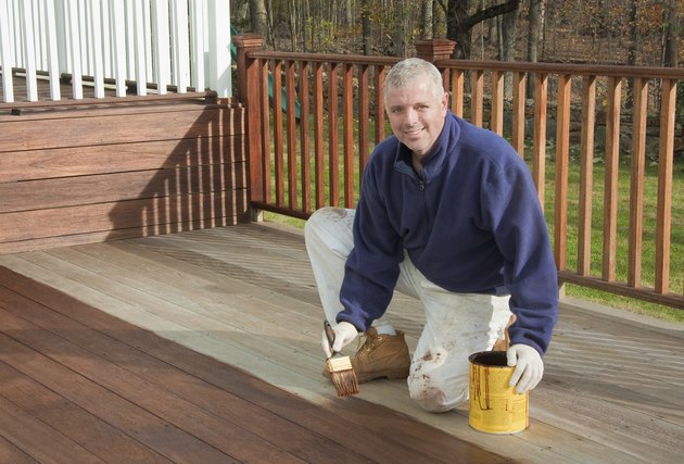 painter or handyman staining a deck