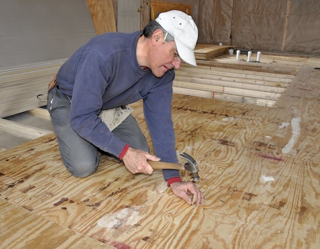 Man nailing down plywood sub-floor
